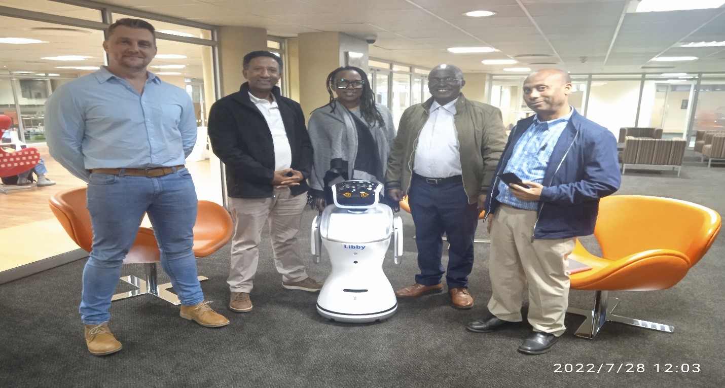The visiting team with  a library representative (left) and  the Library robot, Libby 